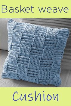 a blue knitted cushion sitting on top of a couch next to a white pillow