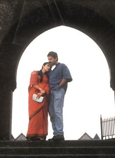 a man and woman standing under an archway