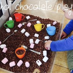 a child is playing with marshmallows and chocolate