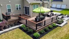 a deck with an umbrella over it in front of a house