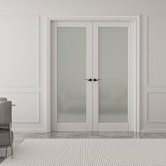 an empty room with white walls and two chairs in front of the glass doors that are open