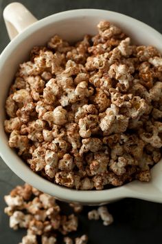 a white bowl filled with popcorn on top of a table