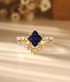 a gold ring with a blue stone surrounded by diamonds