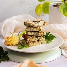 a stack of granola bars sitting on top of a white plate next to a yellow flower