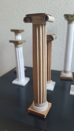 three white and brown pedestals on top of a black table next to each other