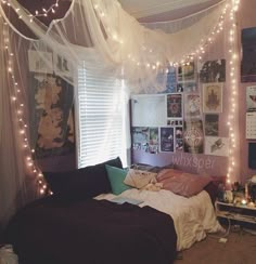 a bedroom with lights strung from the ceiling and pictures on the wall above the bed