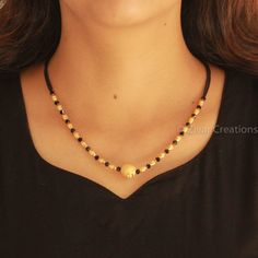 Fancy Mangalsutra with black crystal and brass metal with gold platting beads. Simple and delicate mangalsutra design. The black and gold beaded chain contains a bigger golden bead in the centre. This is a traditional yet modern short mangalsutra pattern that women can go for. Black Beeds Chain Indian Gold Short, Gold Chain With Black Beads, Modern Mangalsutra Designs Gold, Mangalsutra Simple, Fancy Mangalsutra, Modern Mangalsutra Designs, Indian Mangalsutra, Short Mangalsutra, Mangalsutra Chain