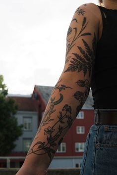 a woman's arm with flowers and birds tattooed on the back of her arm