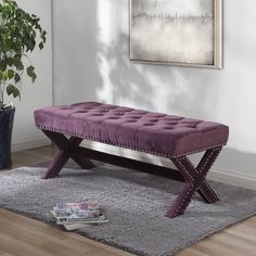 a purple bench sitting on top of a rug next to a plant in a living room