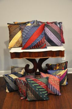 a pile of colorful pillows sitting on top of a wooden table