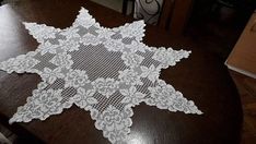 a white doily sitting on top of a wooden table