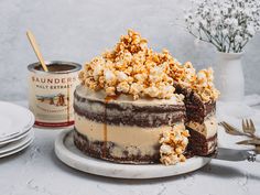 there is a cake that has been decorated with chocolate and caramel popcorn on top