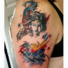 a woman's shoulder with a watercolor tattoo design on her left arm and chest