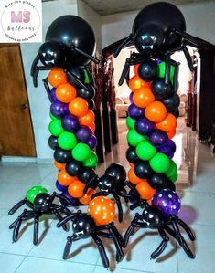 some black and orange balloons are in the shape of spider legs with balls attached to them