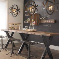 a dining room table with two chairs and a chalkboard on the wall behind it