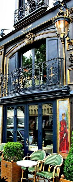 the outside of a restaurant with tables and chairs