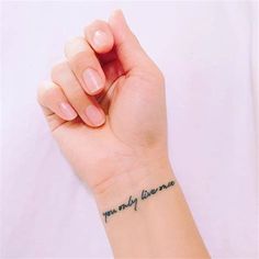 a woman's wrist tattoo with the words you only live once