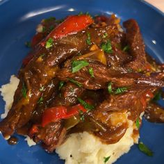 a blue plate topped with mashed potatoes and beef