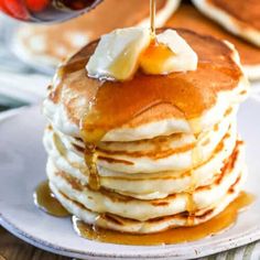 a stack of pancakes with syrup being drizzled on top