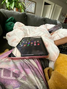 a person laying on a couch with an open tablet