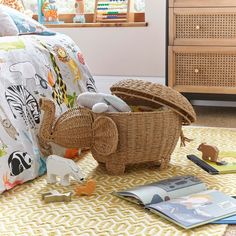 a basket filled with toys sitting on top of a floor next to a bed and dresser