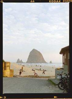 several people are on the beach near some rocks