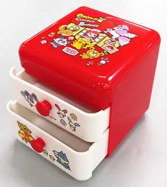 a small red and white toy chest with cartoon characters painted on it's sides