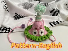 a crocheted hat with eyeballs and a tassel on the top that says pattern - english