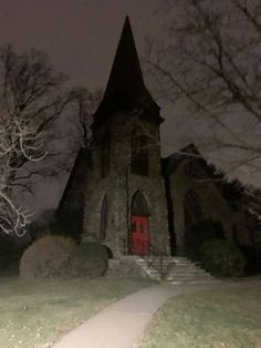 an old church with a red door at night