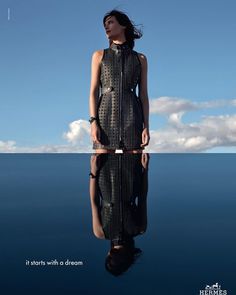 a woman is standing in the water with her reflection