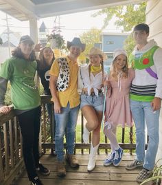 a group of young people standing on top of a wooden porch next to each other