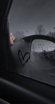 the side view mirror of a car with rain drops on it