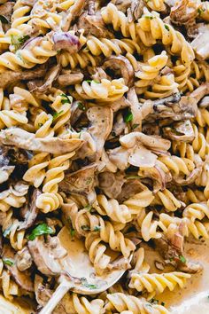 pasta with mushrooms and parsley in a white bowl