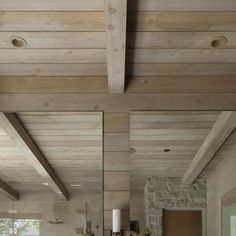 a living room filled with furniture next to a fire place under a wooden ceiling mounted flat screen tv