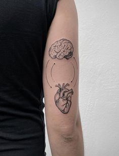 a person with a tattoo on their arm has a heart and brain in the shape of a circle