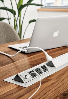 an apple laptop is plugged into the power strip