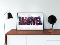 the word marvel is displayed on a wooden shelf next to a black lamp and white cabinet