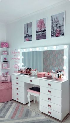 a white dresser with pink drawers and lights on it in front of a large mirror