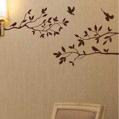 a bird sitting on a tree branch wall decal next to a framed photo frame