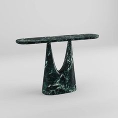 a green marble table with an unusual shaped base