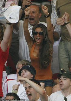 two women and one man are cheering in the stands