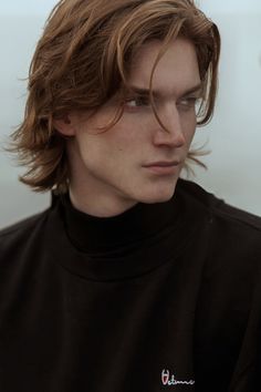 a close up of a person wearing a black shirt and looking off to the side