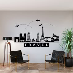 a living room with two chairs and a wall sticker that says travel in front of the eiffel tower