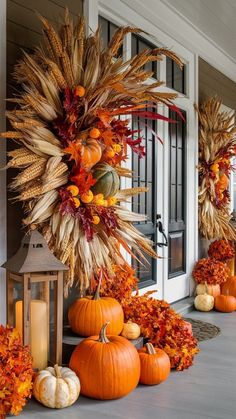 pumpkins and gourds are arranged on the front porch for fall decorating