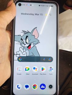 someone holding up an iphone with the cartoon tomy and jerry on it