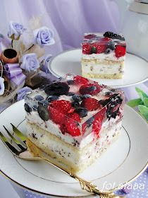 two pieces of cake with berries and blueberries on them