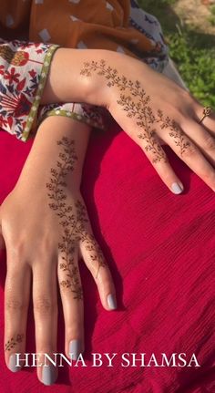 henna by shamsa on her hands and hand, with flowers painted on it