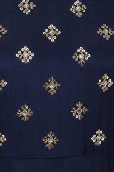 the back of a woman's blue dress with gold and white flowers on it