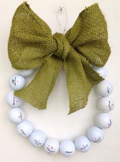 a wreath made out of golf balls with a green bow on the front of it