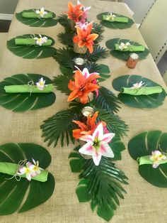 the table is set up with flowers and leaves on top of each other, including lilies